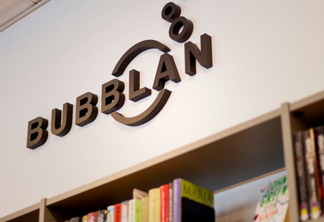Skylt med texten "Bubblan" ovanför en bokhylla.
