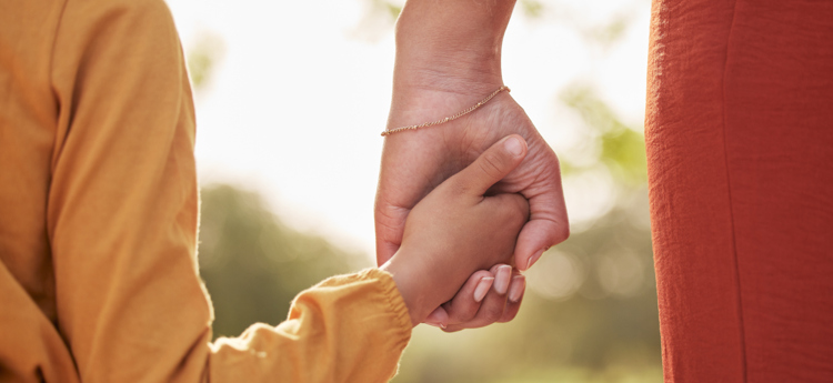 En barnhand och en vuxen hand som håller i varandra.