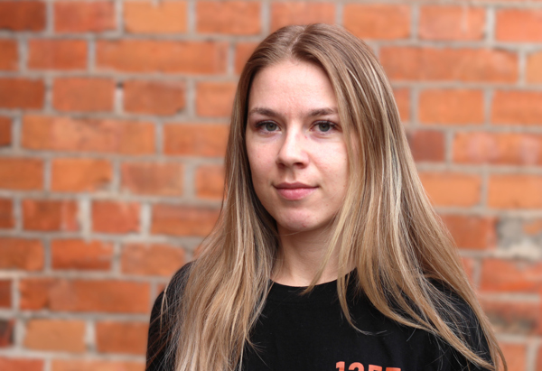 Fritidsledare Elin framför tegelvägg