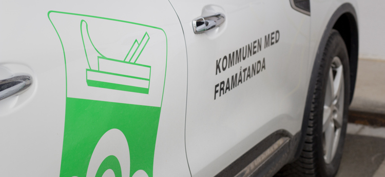 Vit bil med Åtvidabergs kommuns logotyp.