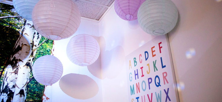 Pappersbollar som hänger i taket och en tavla med alfabetet i starka färger.