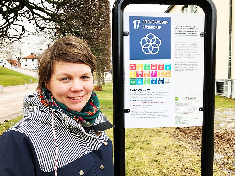 Kommunens hållbarhetsstrateg Linnea Salbark framför en av de 17 skyltarna